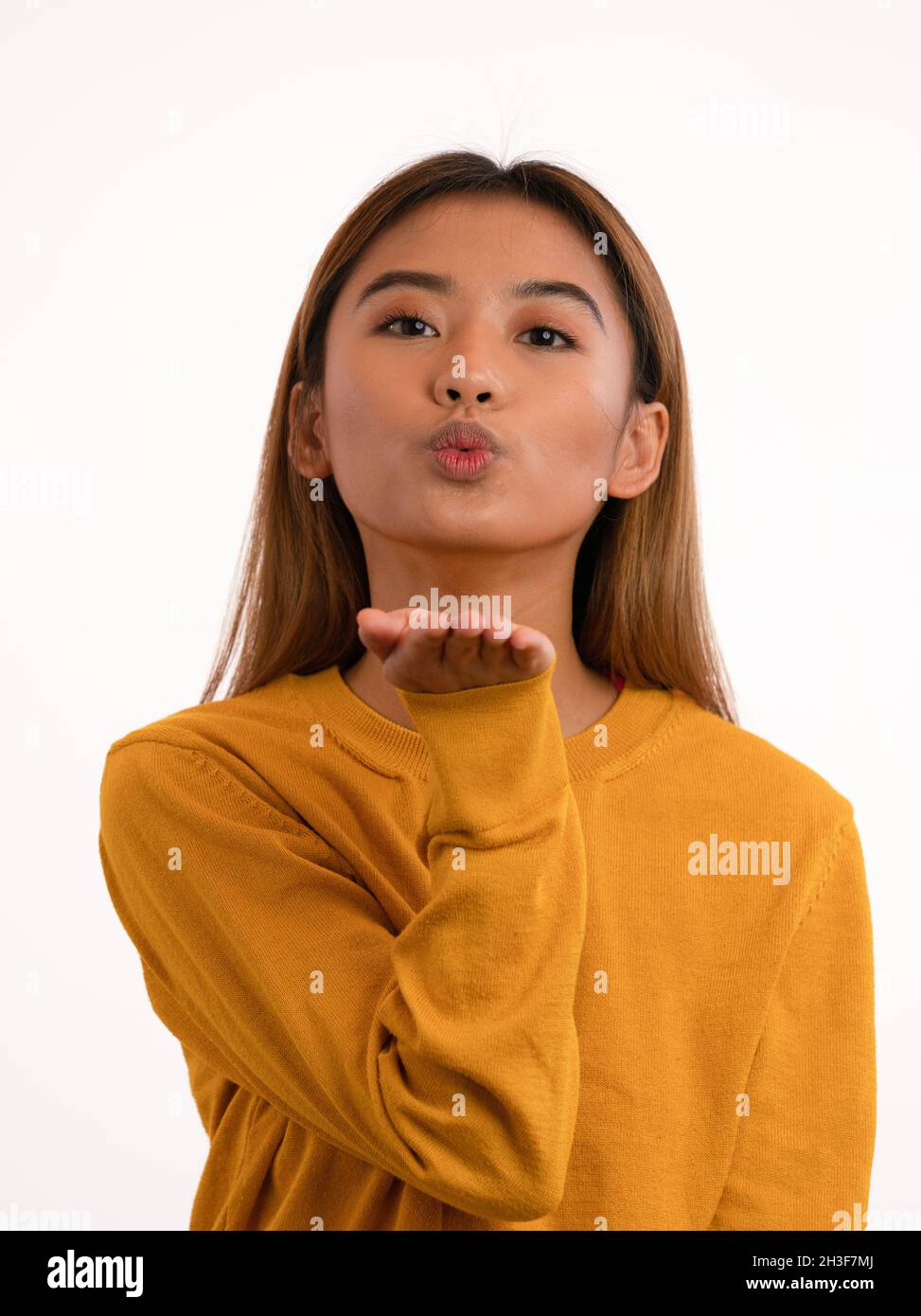 Junge süße attraktive asiatische Mädchen Luft küssen im Studio Stockfoto