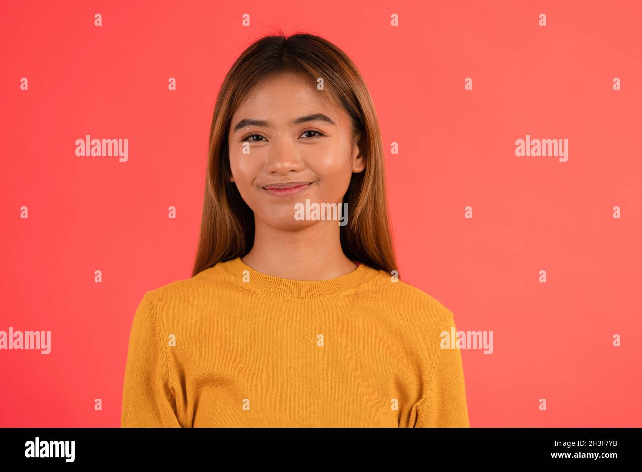 Junge attraktive asiatische Mädchen lächeln im Studio Stockfoto