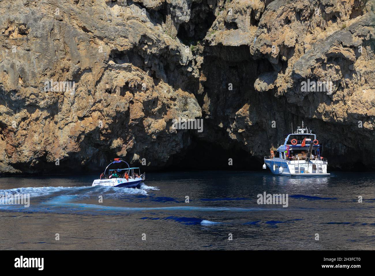 Touristenboote an der Mündung einer Meereshöhle an der Küste von Antalya in der Südtürkei. Stockfoto
