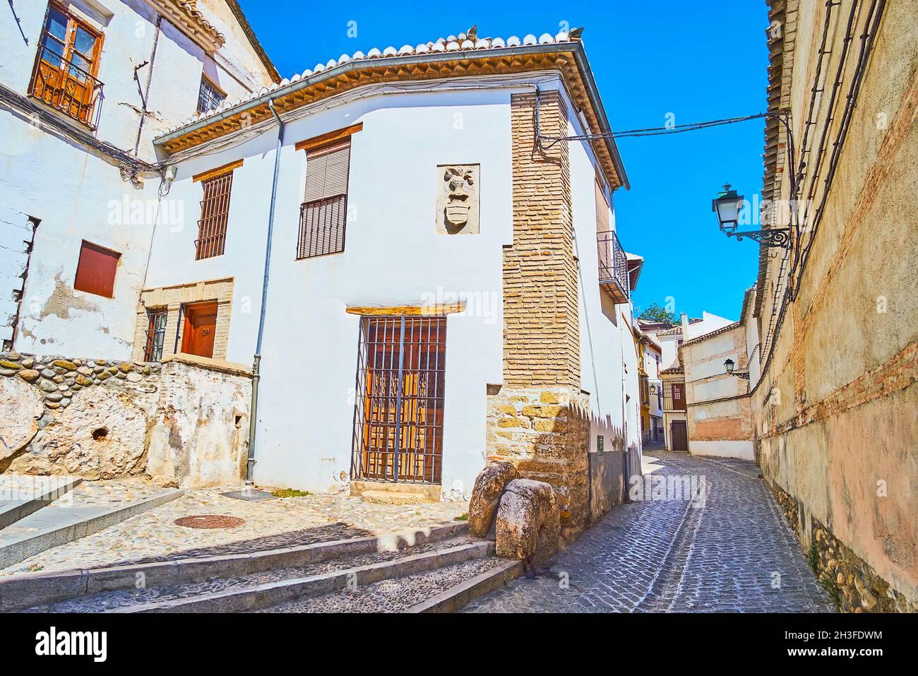 Die enge gewundene und hügelige San Juan de los Reyes stret mit erhaltenen historischen weiß getünchten Häusern, dekoriert mit geschnitzten Steindetails, Albaicin, G Stockfoto