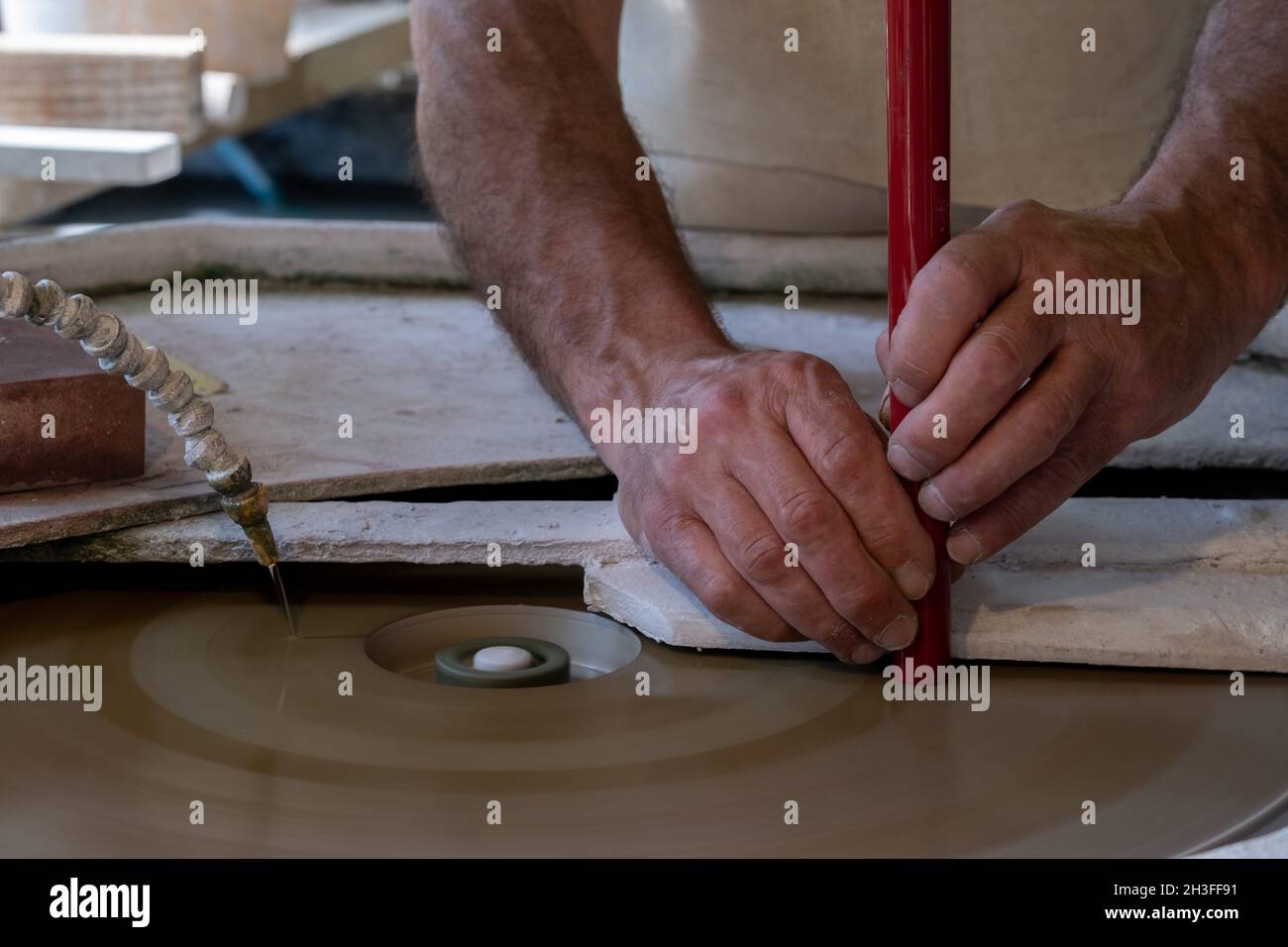 Hände eines Mannes während der kalten Bearbeitung von Glasperlen. Venedig, Italien, 14. Juni 2021. (MVS) Stockfoto