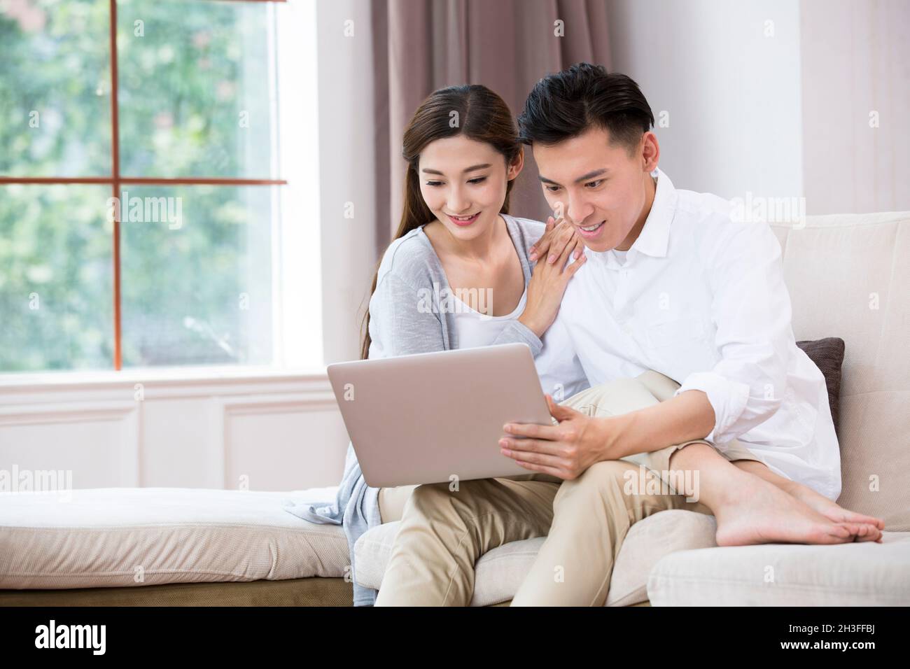 Junges Paar mit einem Laptopcomputer Stockfoto