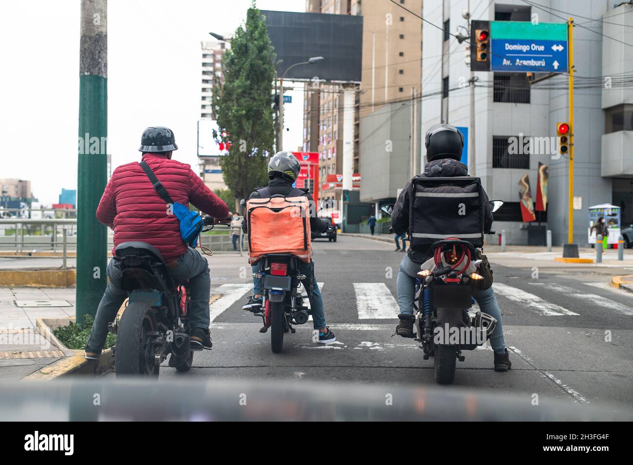 Fahrer mit Rucksack auf einem Motorrad, der auf einer Straße unterwegs ist Stockfoto