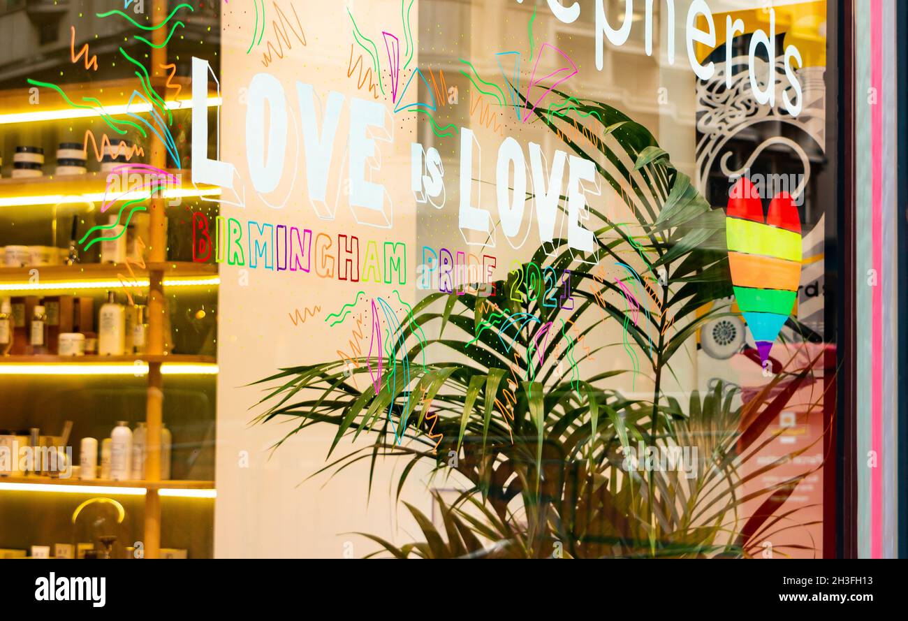 „Love is Love“-Schild am Schaufenster mit stolzen Regenbogengrafiken bei Birmingham Pride Samstag, 25. September 2021 Stockfoto