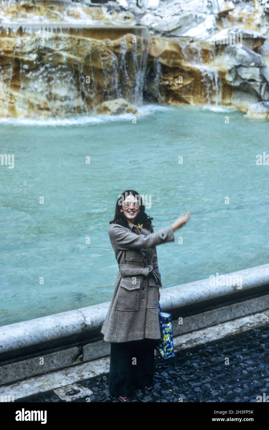Siebziger Jahre, eine junge Frau wirft eine Münze in den Trevi-Brunnen, Rom, Italien Stockfoto