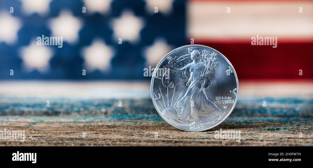 Nahaufnahme einer amerikanischen Silberdollar-Münze mit US-Flagge im Hintergrund Stockfoto