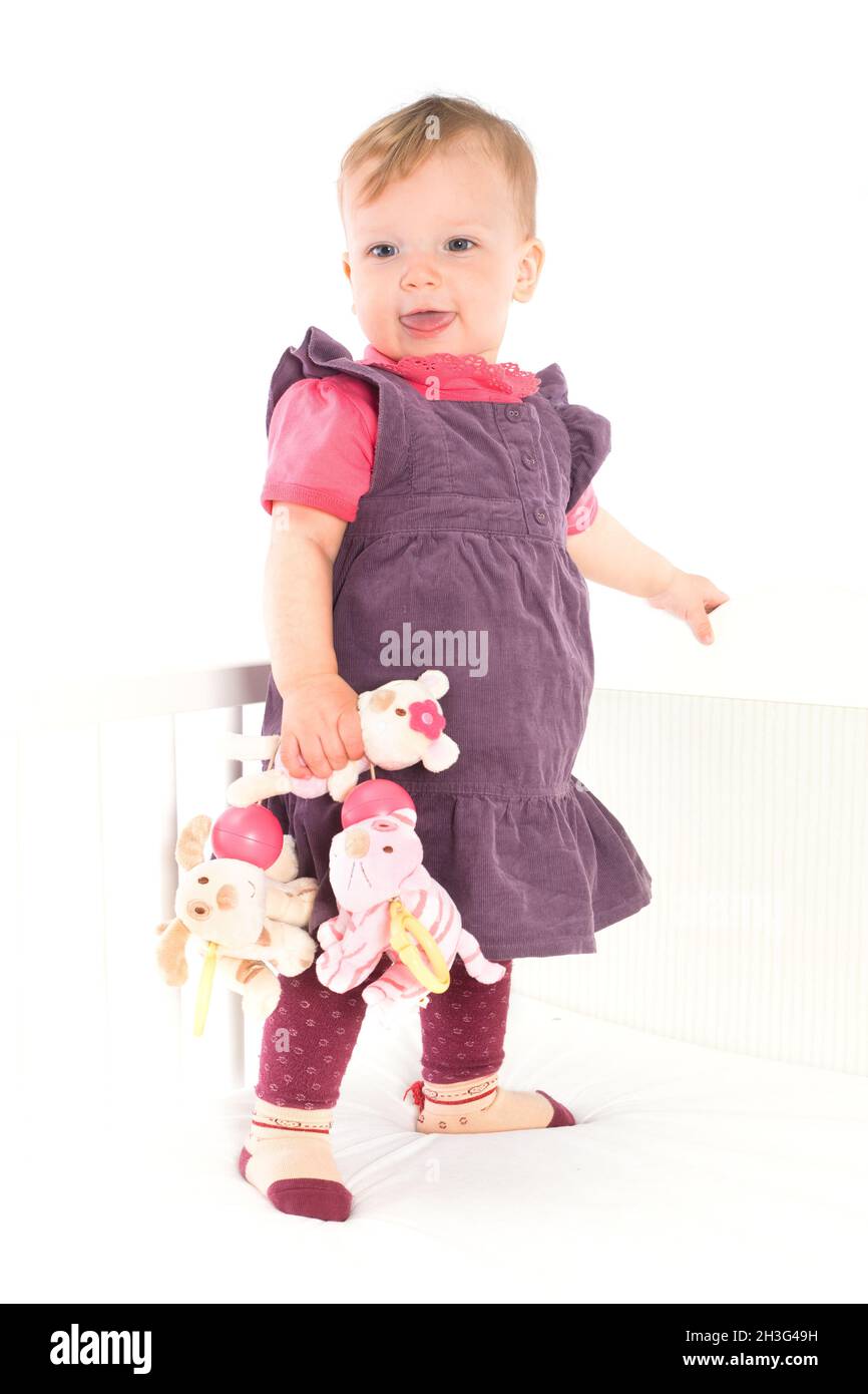 Baby Mädchen auf der Krippe stehen Stockfoto