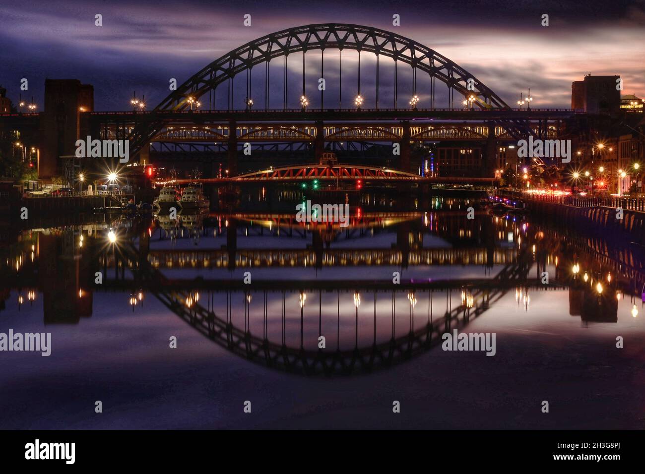 Tyne-Brücken spiegeln sich im Tyne nach Einbruch der Dunkelheit Stockfoto