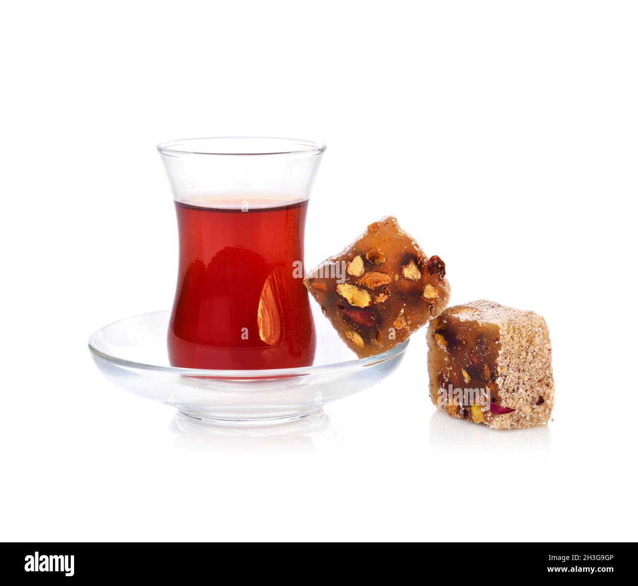 Traditionelles türkisches Delight rahat Lokum mit einem Glas Tee auf weißem Hintergrund Stockfoto