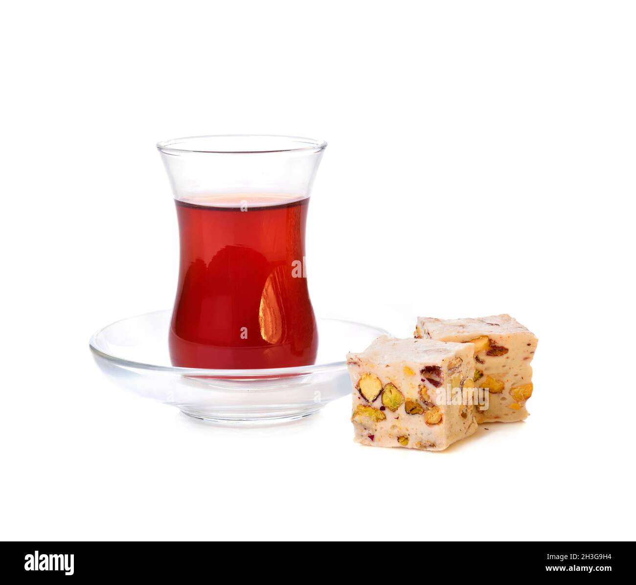 Traditionelles türkisches Delight rahat Lokum mit einem Glas Tee auf weißem Hintergrund Stockfoto