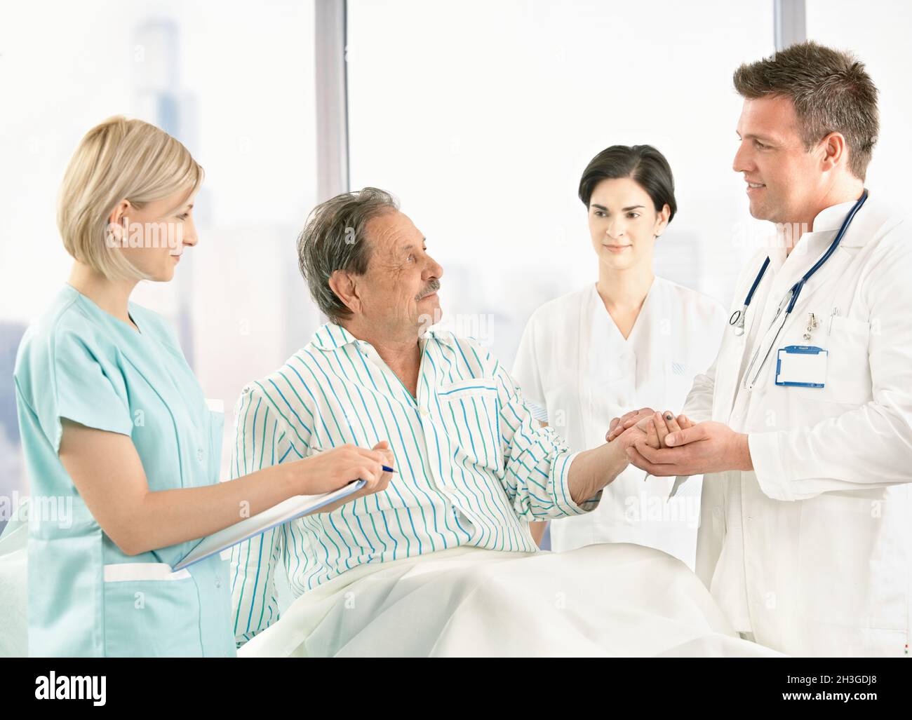 Ärzte sprechen mit alten Patienten im Krankenhaus Stockfoto