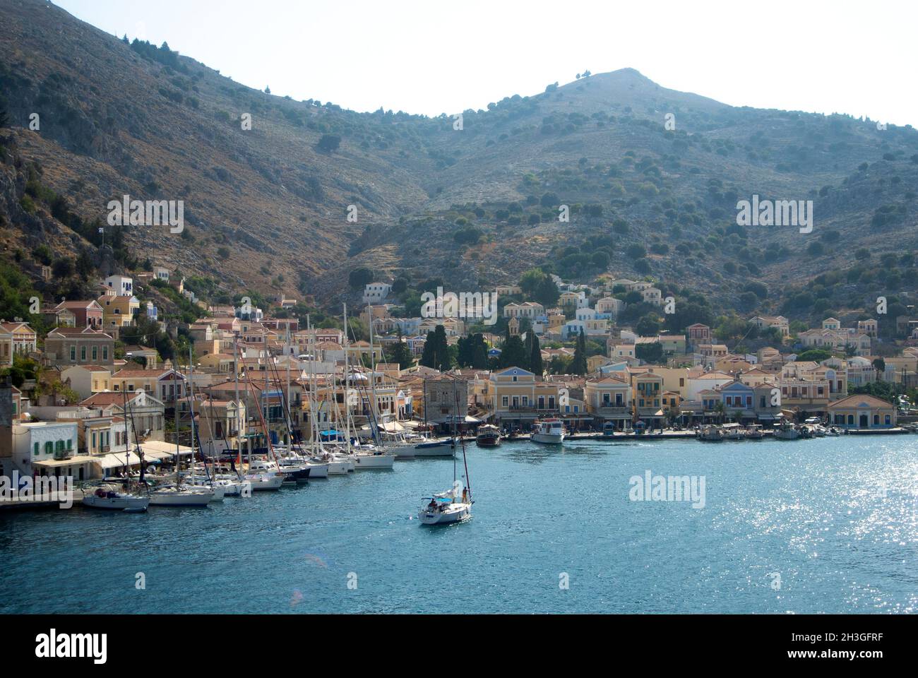 Wunderschöne Symi Insel, Griechenland dramatische Aussicht auf den alten Hafen mit neoklassizistischen Häusern an den Hängen, Landschaftsansicht Stockfoto