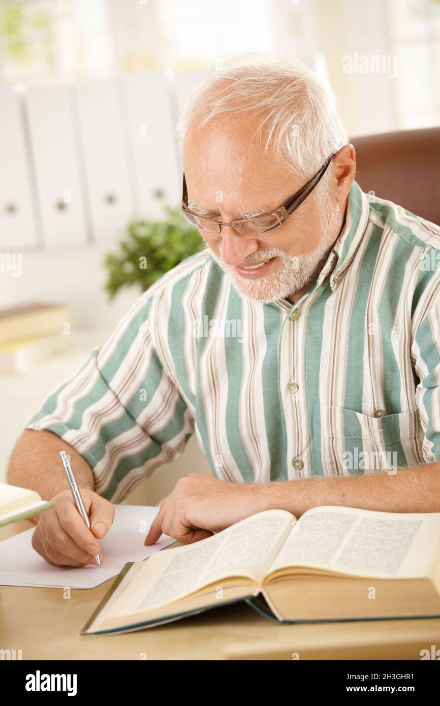 Weißer Haar Rentner Schreiben Brief zu Hause Stockfoto