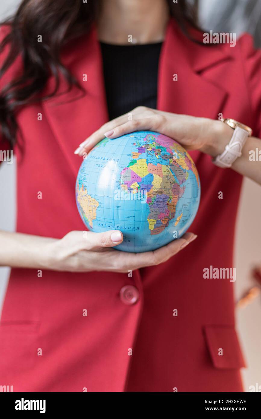 Die Frau hält den Globus in ihren Händen. Reisekonzept, Hintergrund Stockfoto