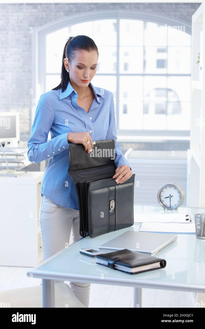 Geschäftsfrau beim Packen der Aktentasche im Büro Stockfoto