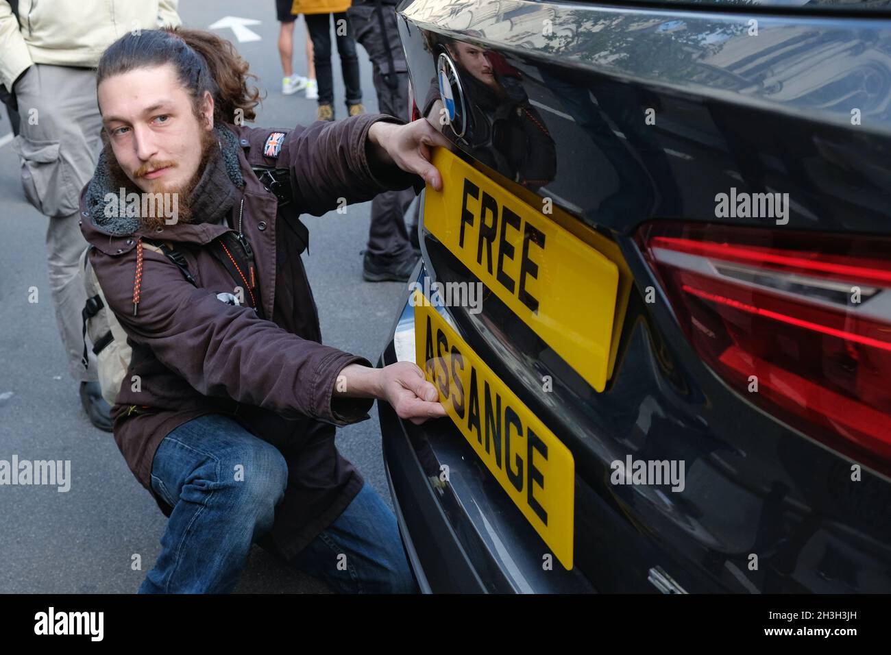 London, Großbritannien. Ein Protestler hält zwei Nummernschilder gegen ein Auto zur Unterstützung des WikiLeaks-Gründers Julian Assange während seiner Berufungsverhandlung in den USA. Stockfoto