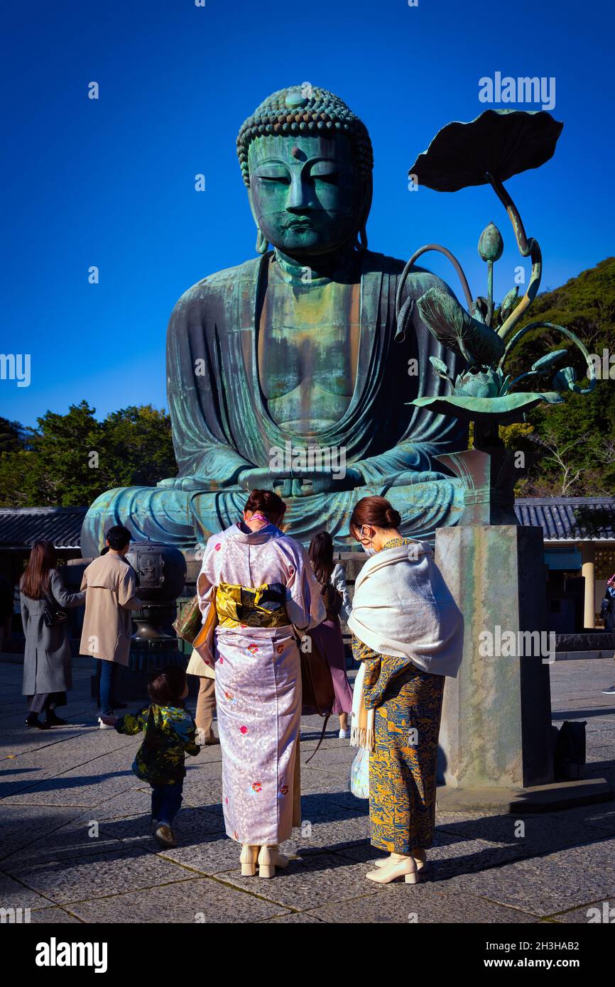 Frauen, die traditionelle Kimonos tragen, besuchen den Großen Buddha oder Kamakura Daibutsu, der 1252 in Kamakura, Japan, fertiggestellt wurde. Stockfoto