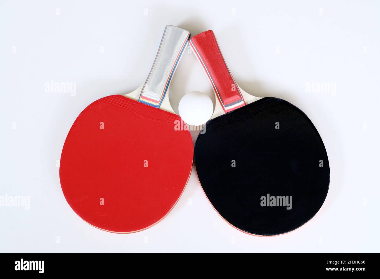 Tischtennis-Paddel und Ball auf weißem Hintergrund. Stockfoto