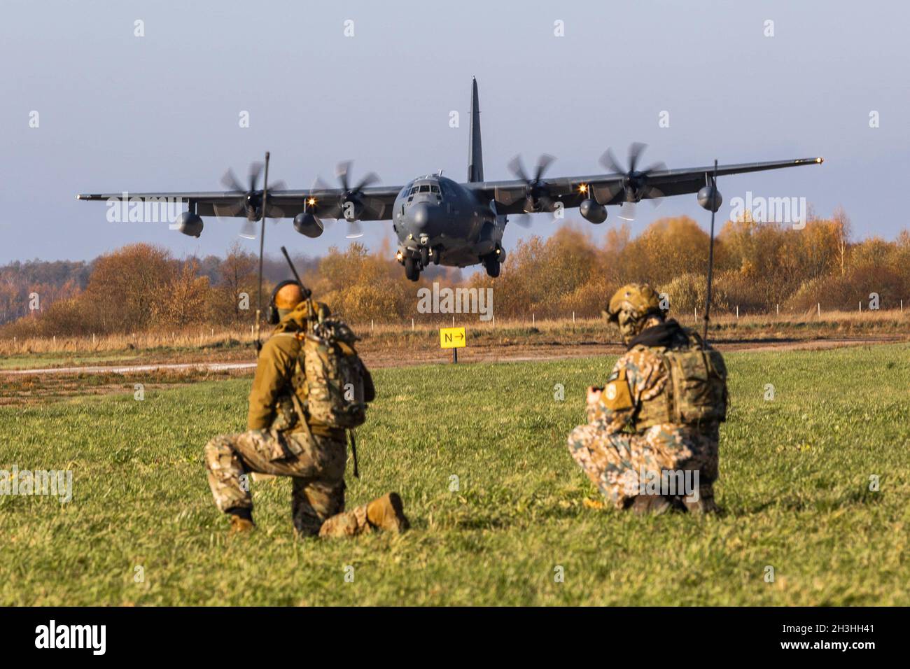 Ein Joint Terminal Attack Controller (JTAC) der lettischen Spezialeinsatzeinheit und ein Sondereinsatzkontrolleur der US-Luftwaffe leiten einen ankommenden MC-130J Commando II, der im Rahmen einer bilateralen Übung im Oktober 25 2021 in Riga, Lettland, dem 352. Spezialeinsatzflügel zugewiesen wurde. Das Flugzeug transportierte einen Zug, der für das High Mobility Artillery Rocket System (HIMARS) der Wisconsin Army National Guard verantwortlich war, und demonstrierte die schnellen, einsatzbereiten Fähigkeiten, die spezielle Operationen für konventionelle Kräfte in kargen Umgebungen ermöglichen. (USA Army Photo von Sgt. Patrik Orcutt) Stockfoto