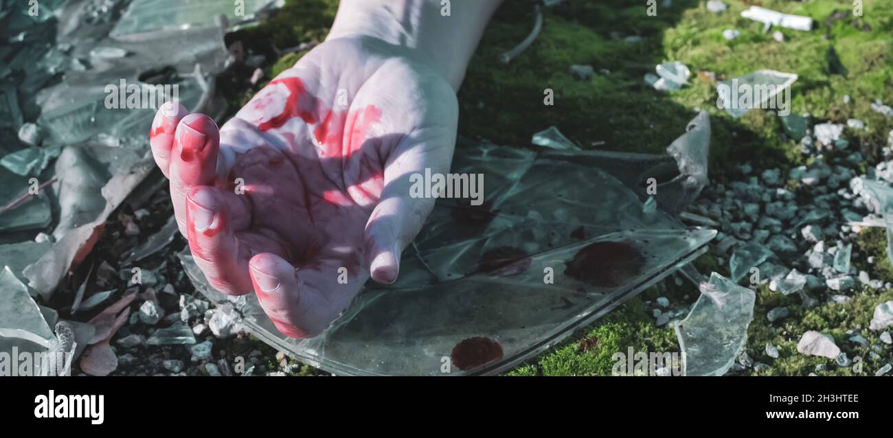 Die Hand des Mannes ist auf dem Asphalt auf dem zerbrochenen Glas auf der Straße nach dem Die Hand des Mannes ist auf dem Asphalt auf dem zerbrochenen Glas auf der Straße nach dem