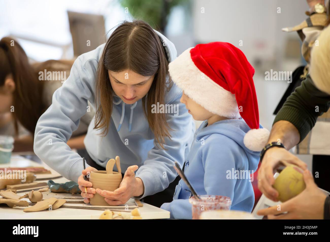 Weißrussland, die Stadt Gomel, 14. Januar 2021. Kreativworkshop. Ein Töpfer lehrt einen kleinen Jungen, mit Ton zu Formen. Stockfoto
