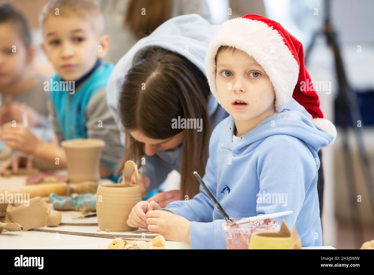 Weißrussland, die Stadt Gomel, 14. Januar 2021. Kreativworkshop. Ein Töpfer lehrt einen kleinen Jungen, mit Ton zu Formen. Stockfoto