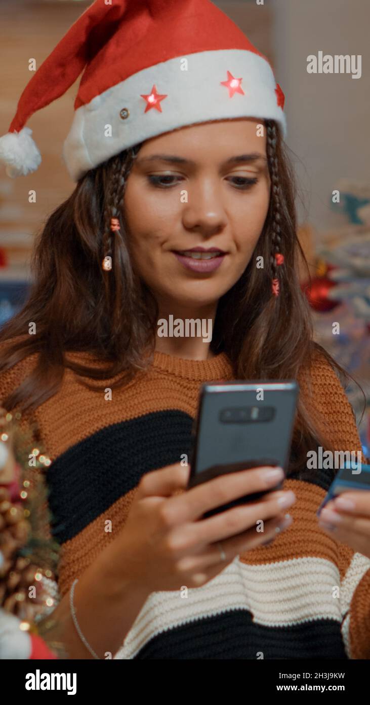 Glückliche Frau auf der Suche nach weihnachtsgeschenken zu Hause