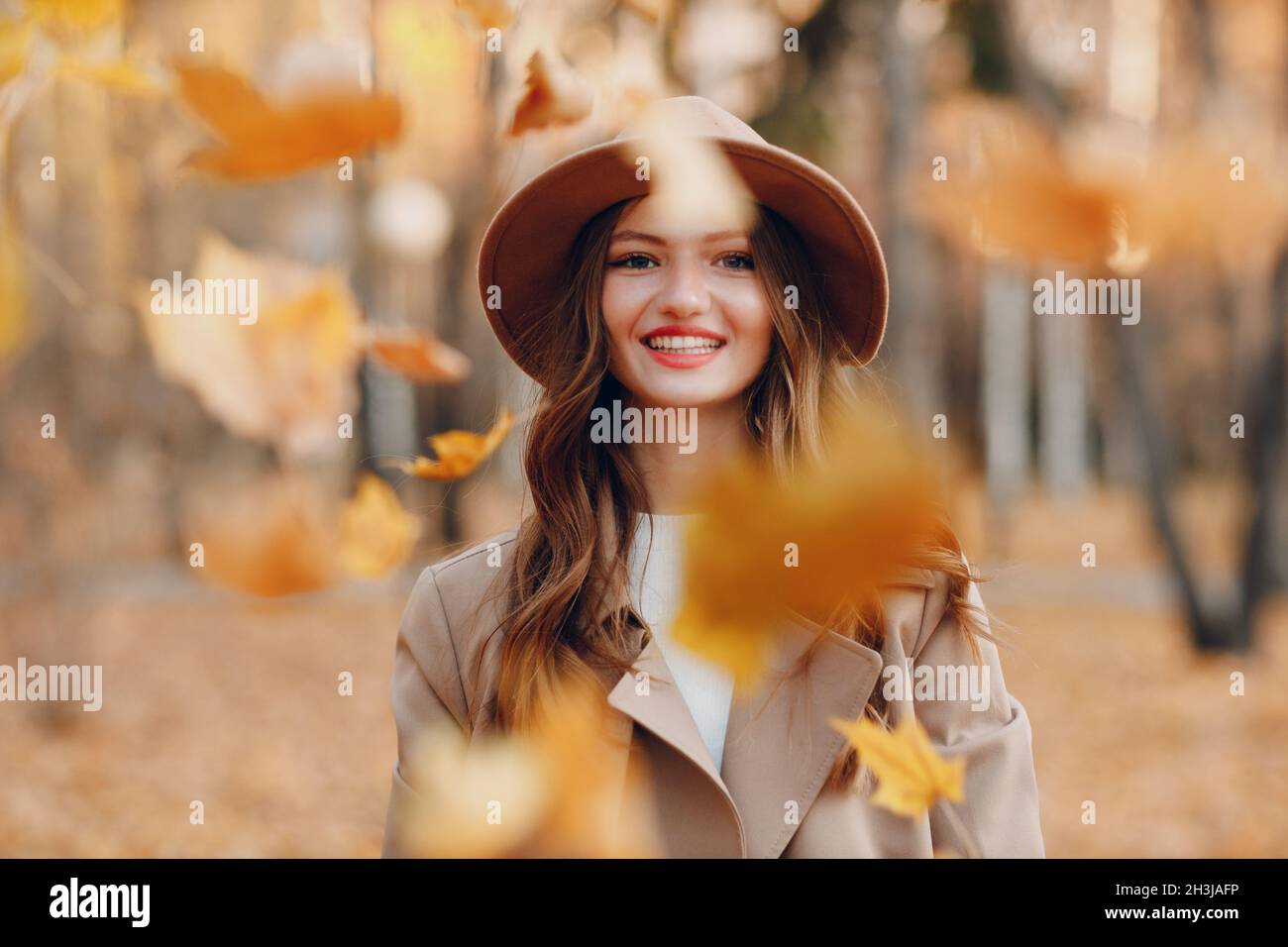 Junge Frau Modell im Herbst Park mit gelben Laub Ahornblätter. Das Blatt fällt herunter Stockfoto