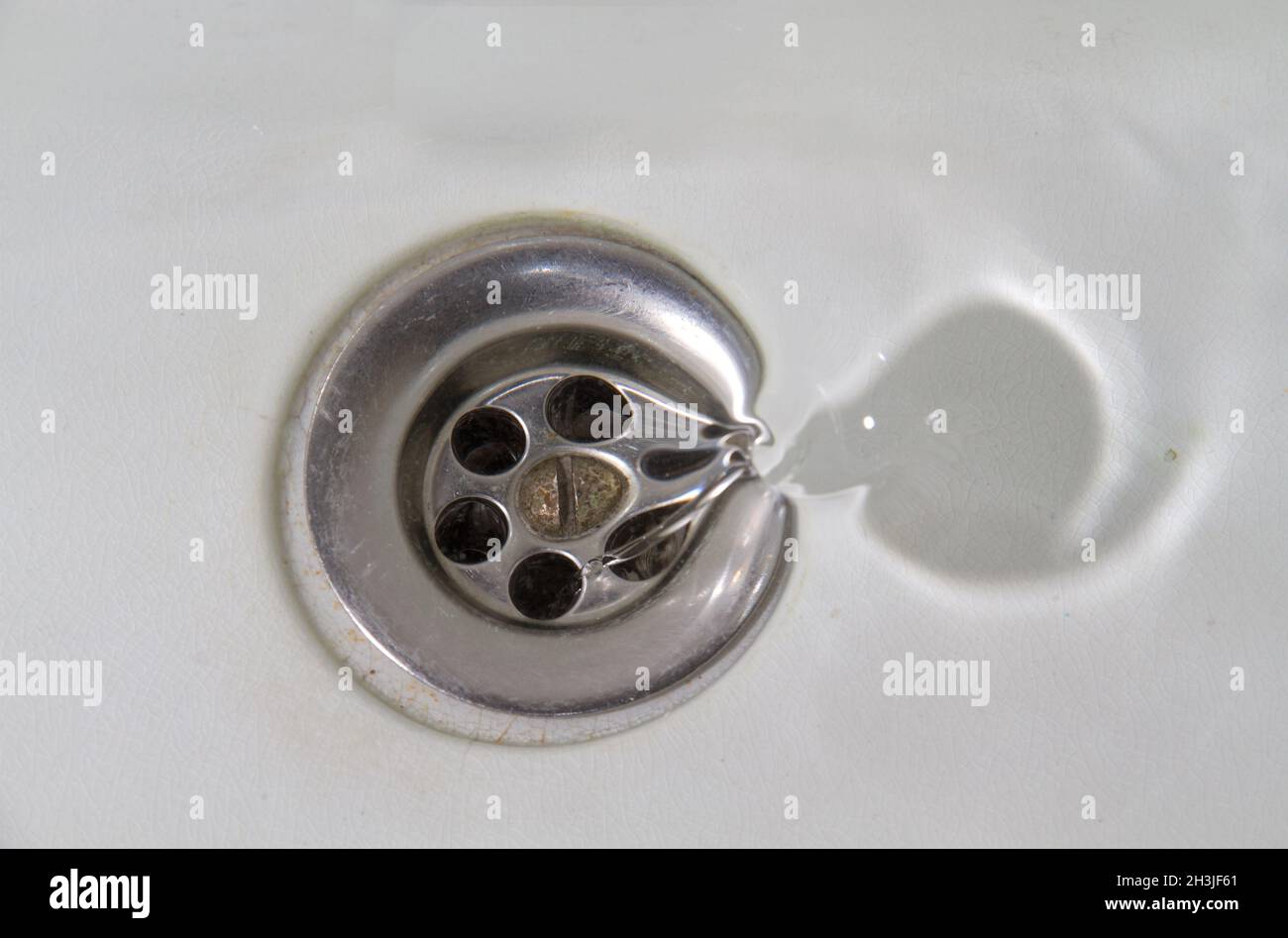 Wasser fließt in ein Waschbecken aus weißem Stein Stockfoto
