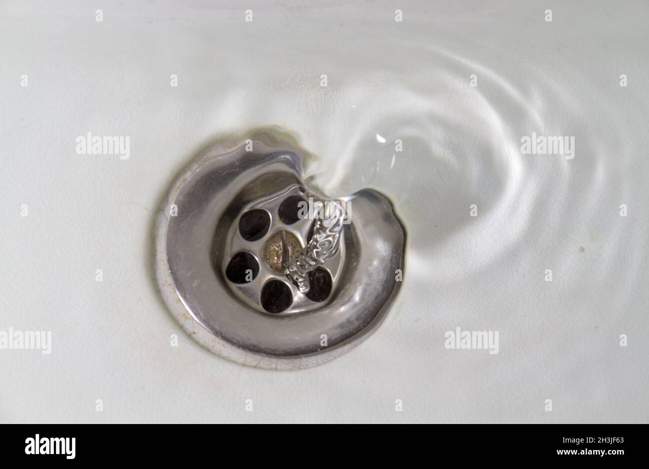 Wasser fließt in ein Waschbecken aus weißem Stein Stockfoto