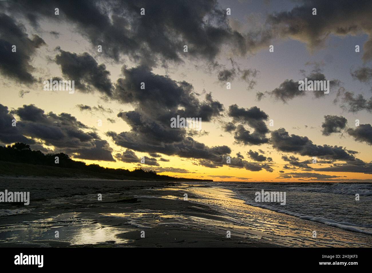 Sonnenuntergang an der ostseeküste mit Wolken am Himmel. Dazu das Rauschen des Meeres und eine frische Brise um die Nase. Stockfoto