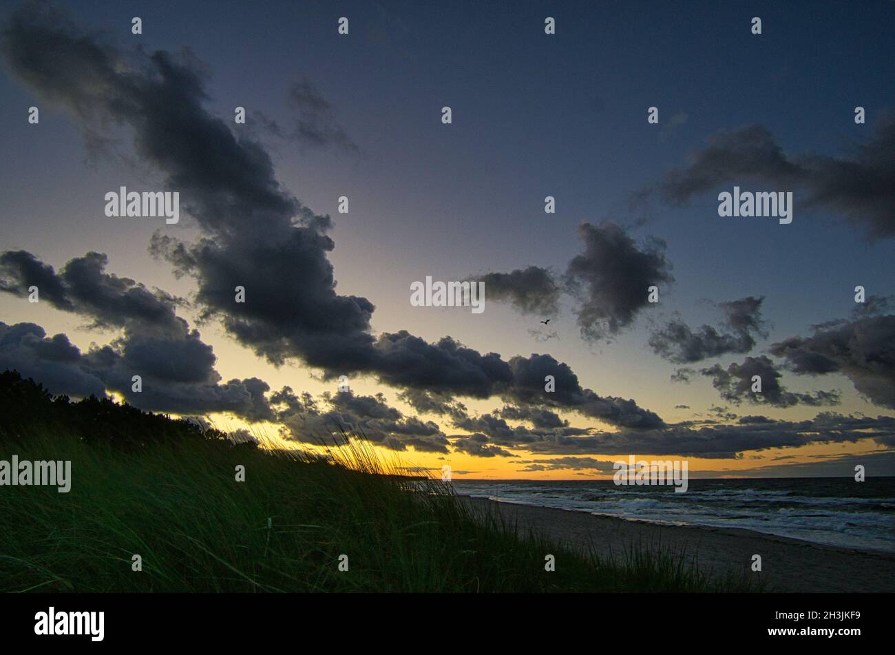 Sonnenuntergang an der ostseeküste mit Wolken am Himmel. Dazu das Rauschen des Meeres und eine frische Brise um die Nase. Stockfoto