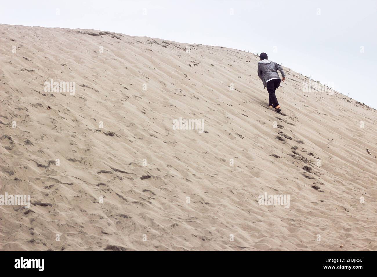 Ein Mann, der auf einer Sanddüne in yogyakarta geht Stockfoto