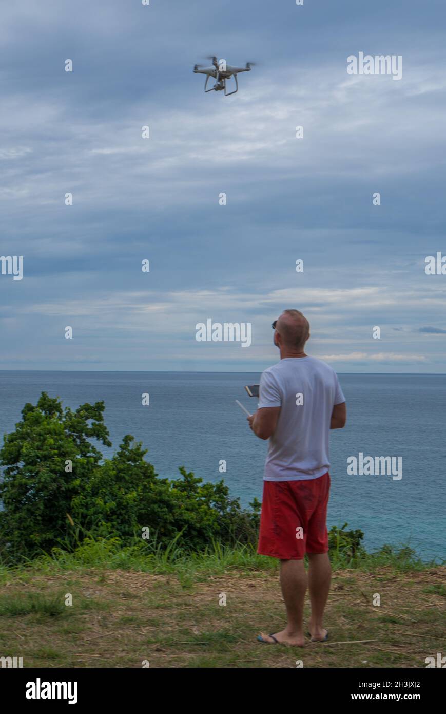 Mann mit Drohnenkamera, der Fotos vom schönen Meer gemacht hat Stockfoto