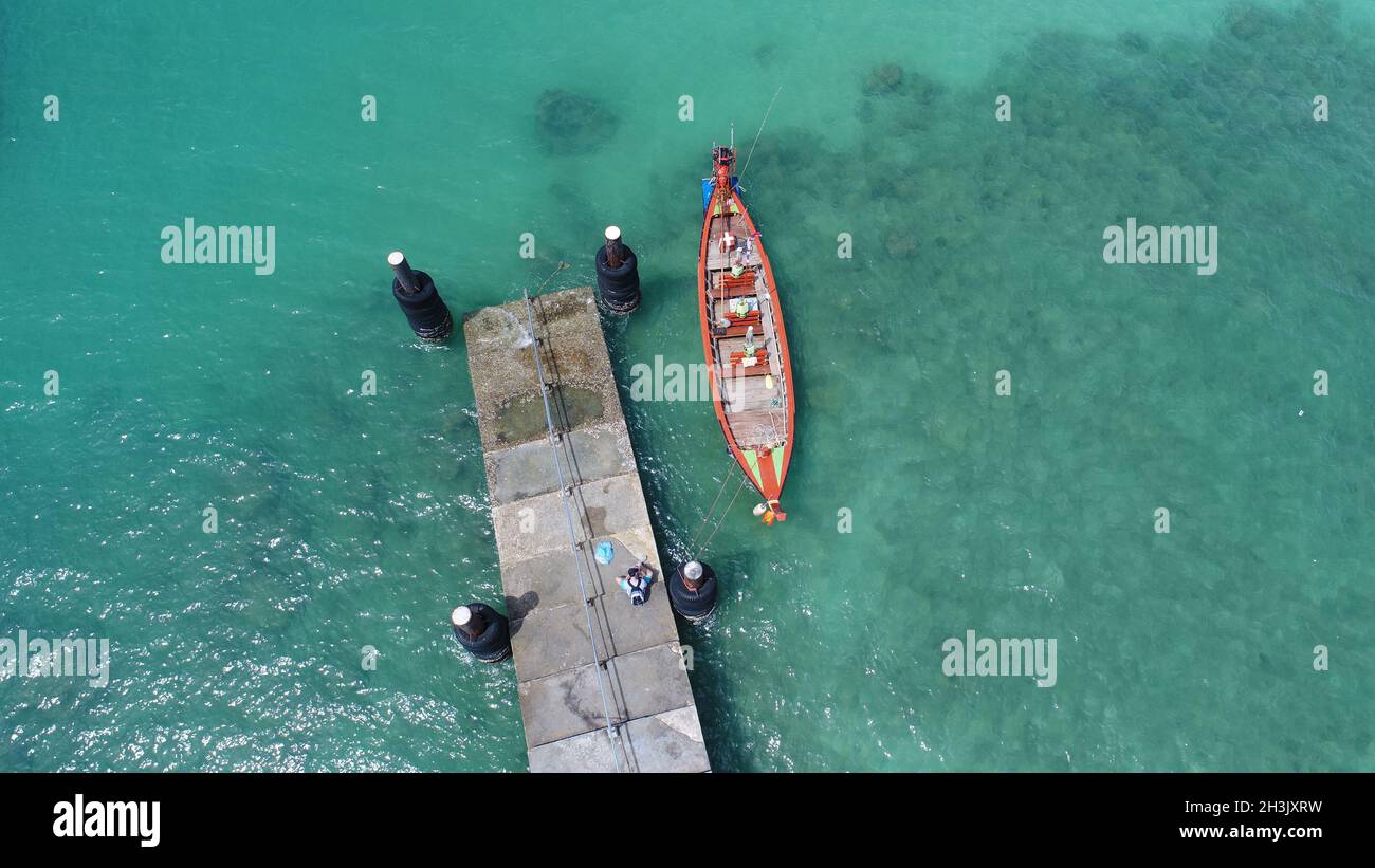 Luftaufnahme Drohne Foto von oben auf dem schwimmenden Boot auf der Wasseroberfläche und Pier am Rawai Strand in Phuket Stockfoto
