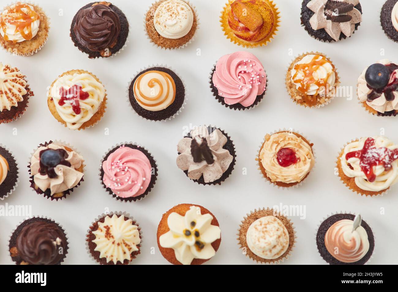Viele bunte Cupcakes von oben mit Toppings und Dekorationen für einen Geburtstag Stockfoto