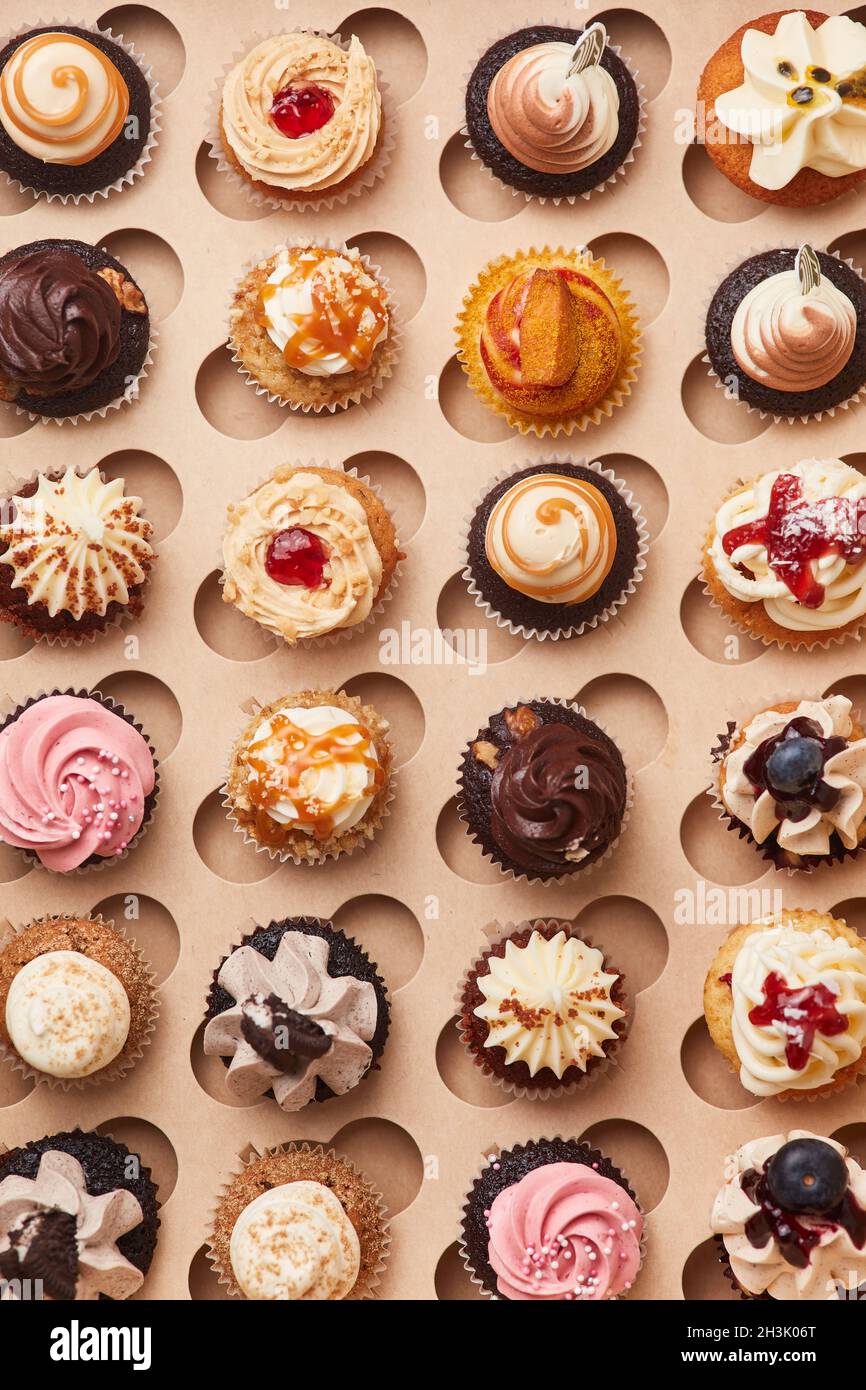 Viele verschiedene süße Cupcakes mit bunten Belägen von oben Stockfoto