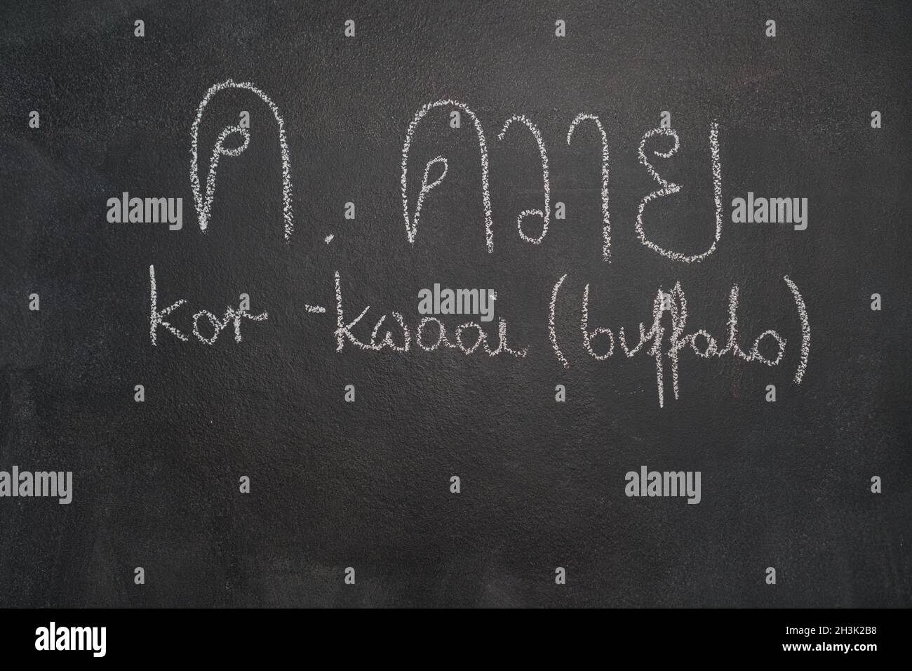 Thailändischer Brief auf schwarzer Tafel geschrieben Stockfoto