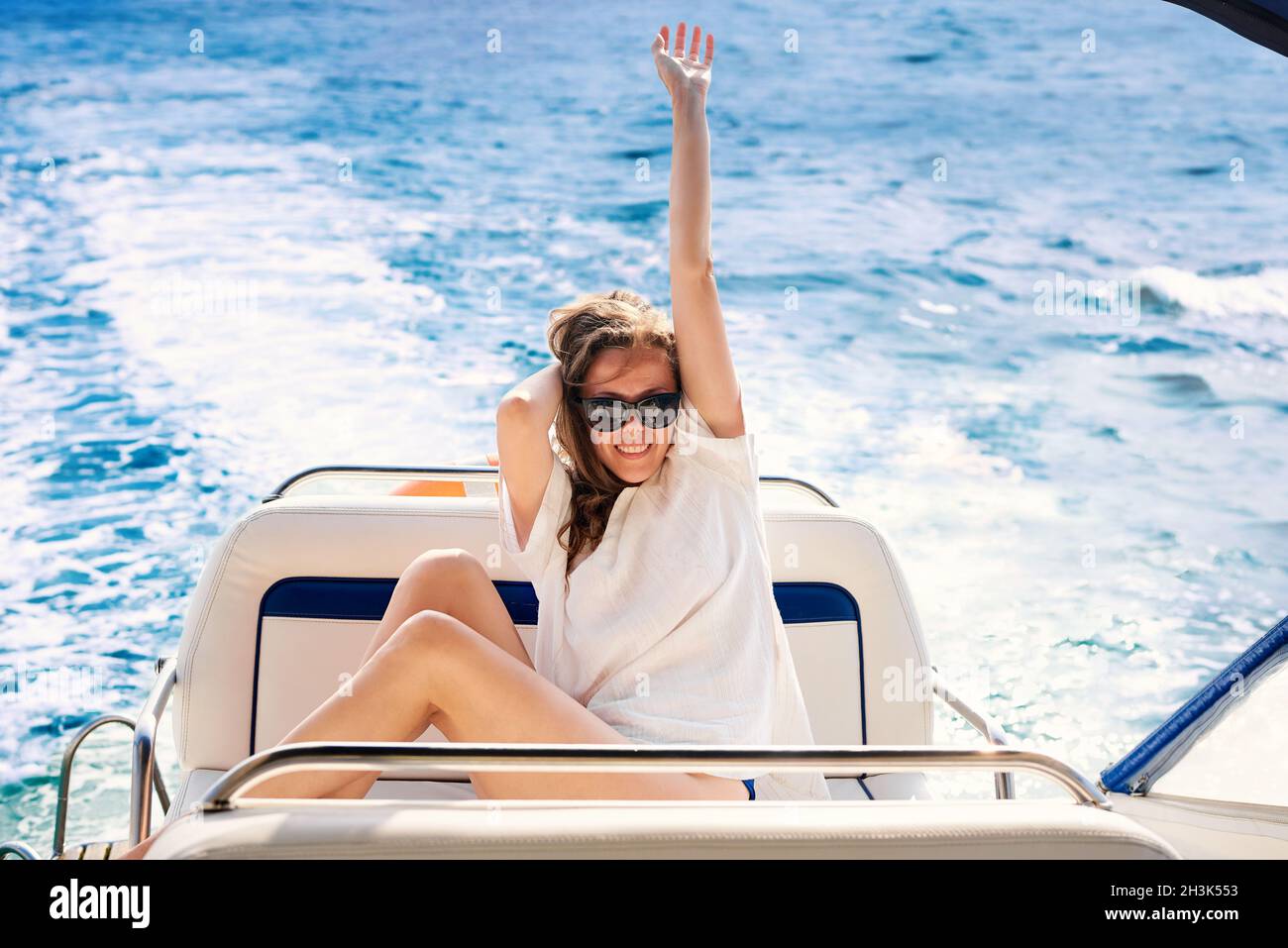 Glückliche junge Frau segelt auf einer Yacht im Meer. Stockfoto