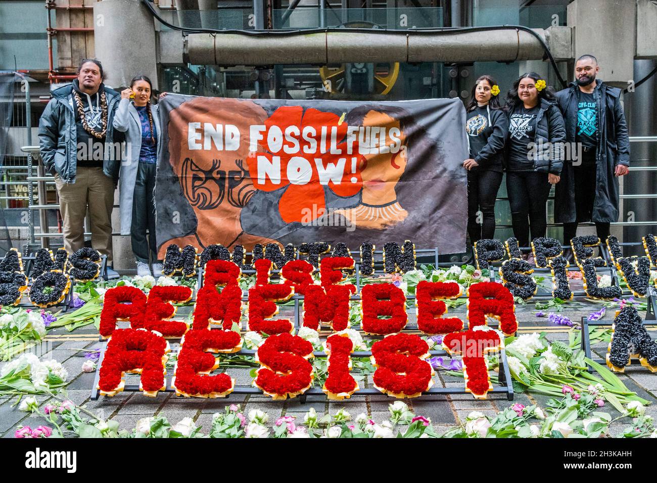 London, Großbritannien. 29 Okt 2021. Pazifische Klimakrieger zollen den vom Klimawandel bedrohten Menschen auf ihren Heimatinseln florale Anerkennung - Demonstranten vom Coal Action Network haben bei Lloyd's of London ein Mahnmal für Klimagerechtigkeit eingerichtet, um an Gemeinden an vorderster Front des Klimawandels zu erinnern, die direkt von schädlichen Projekten betroffen sind Und Klimaauswirkungen. An der Gedenkstätte wurden Hunderte von Blumen und Blumenkränzen im Freien gelegt. Blumen mit über 600 individuellen Botschaften von Menschen aus ganz Großbritannien wurden an Mitarbeiter verteilt, die im Lloyd's Gebäude ein- und ausgingen. Kredit: Guy Bell/Alamy Live N Stockfoto