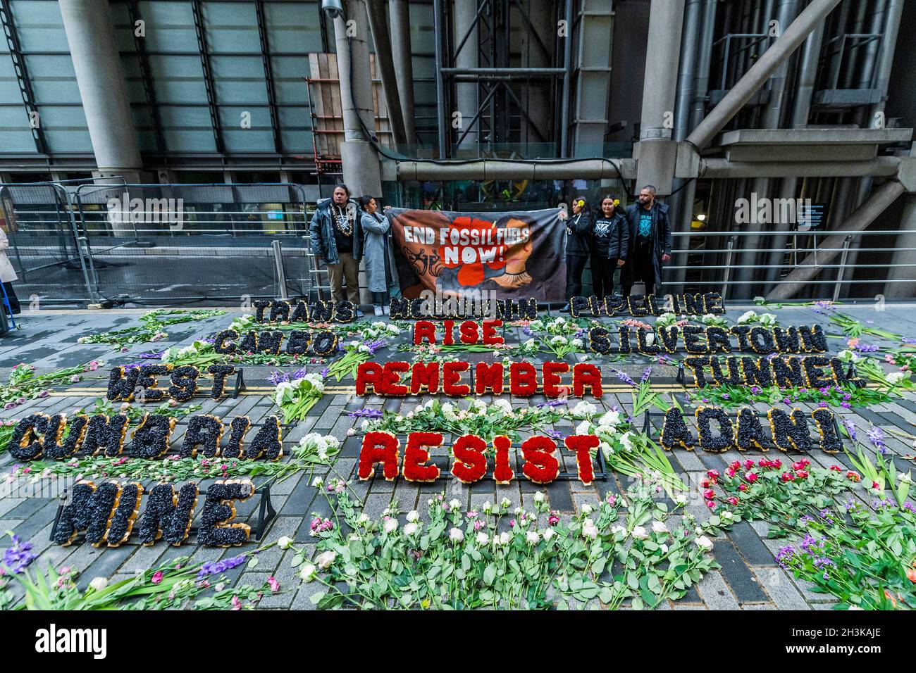 London, Großbritannien. 29 Okt 2021. Pazifische Klimakrieger zollen den vom Klimawandel bedrohten Menschen auf ihren Heimatinseln florale Anerkennung - Demonstranten vom Coal Action Network haben bei Lloyd's of London ein Mahnmal für Klimagerechtigkeit eingerichtet, um an Gemeinden an vorderster Front des Klimawandels zu erinnern, die direkt von schädlichen Projekten betroffen sind Und Klimaauswirkungen. An der Gedenkstätte wurden Hunderte von Blumen und Blumenkränzen im Freien gelegt. Blumen mit über 600 individuellen Botschaften von Menschen aus ganz Großbritannien wurden an Mitarbeiter verteilt, die im Lloyd's Gebäude ein- und ausgingen. Kredit: Guy Bell/Alamy Live N Stockfoto