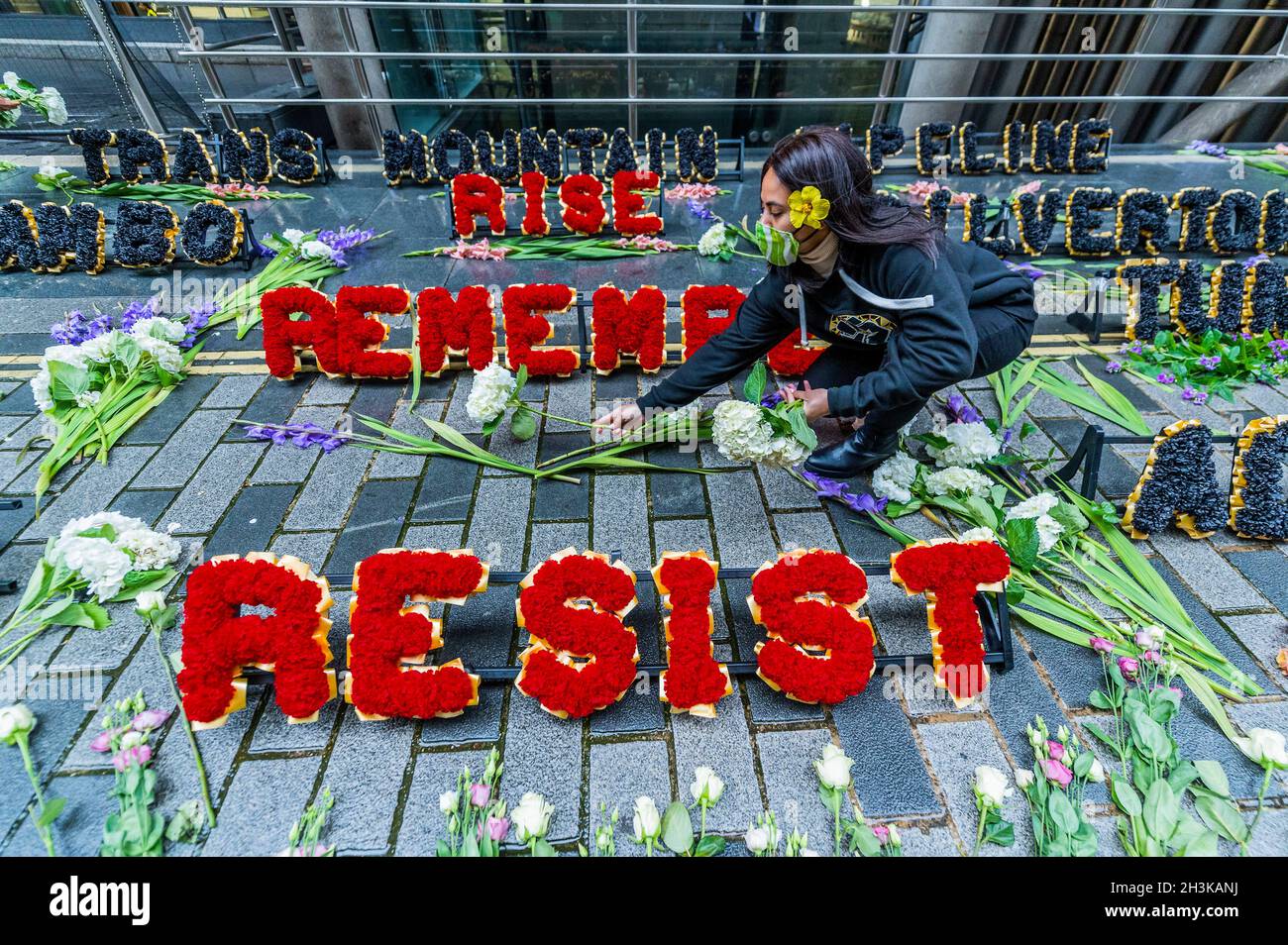 London, Großbritannien. 29 Okt 2021. Pazifische Klimakrieger zollen den vom Klimawandel bedrohten Menschen auf ihren Heimatinseln florale Anerkennung - Demonstranten vom Coal Action Network haben bei Lloyd's of London ein Mahnmal für Klimagerechtigkeit eingerichtet, um an Gemeinden an vorderster Front des Klimawandels zu erinnern, die direkt von schädlichen Projekten betroffen sind Und Klimaauswirkungen. An der Gedenkstätte wurden Hunderte von Blumen und Blumenkränzen im Freien gelegt. Blumen mit über 600 individuellen Botschaften von Menschen aus ganz Großbritannien wurden an Mitarbeiter verteilt, die im Lloyd's Gebäude ein- und ausgingen. Kredit: Guy Bell/Alamy Live N Stockfoto