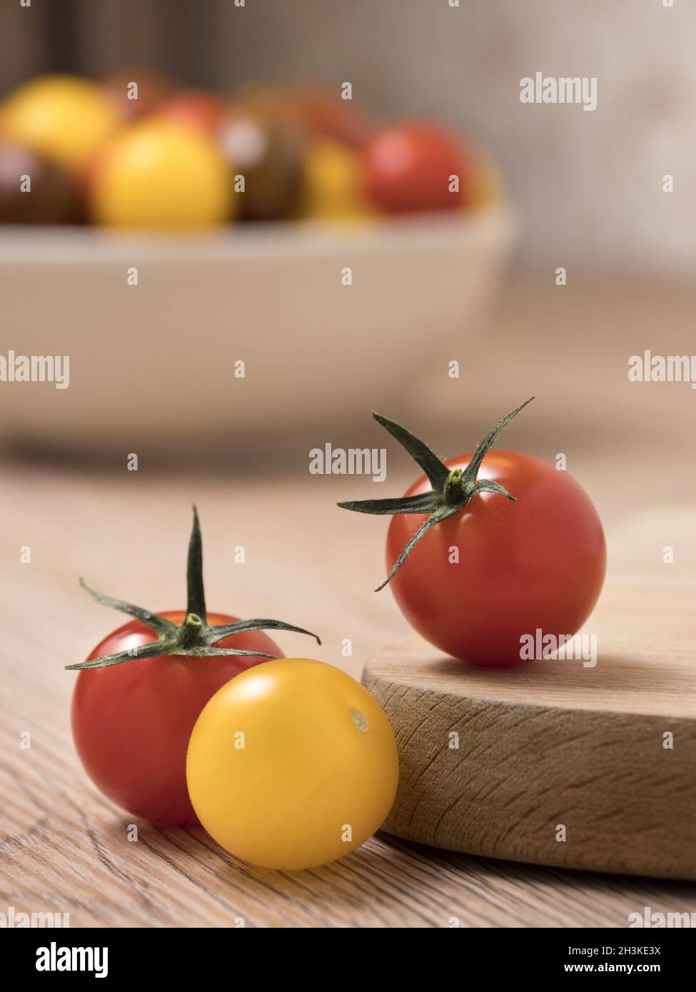 Kirschtomaten in verschiedenen Farben auf einem Holztisch. Stockfoto