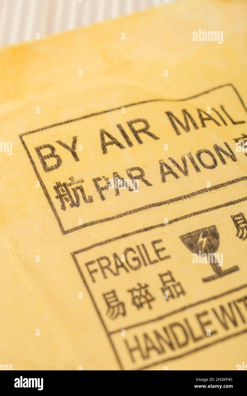 Chinesisches Par Avion-Luftpostetikett auf gelb-braunem Briefumschlagversand/Paket aus China. Für chinesische Exporte, Werkstatt der Welt. Fokus auf „Par“ Stockfoto