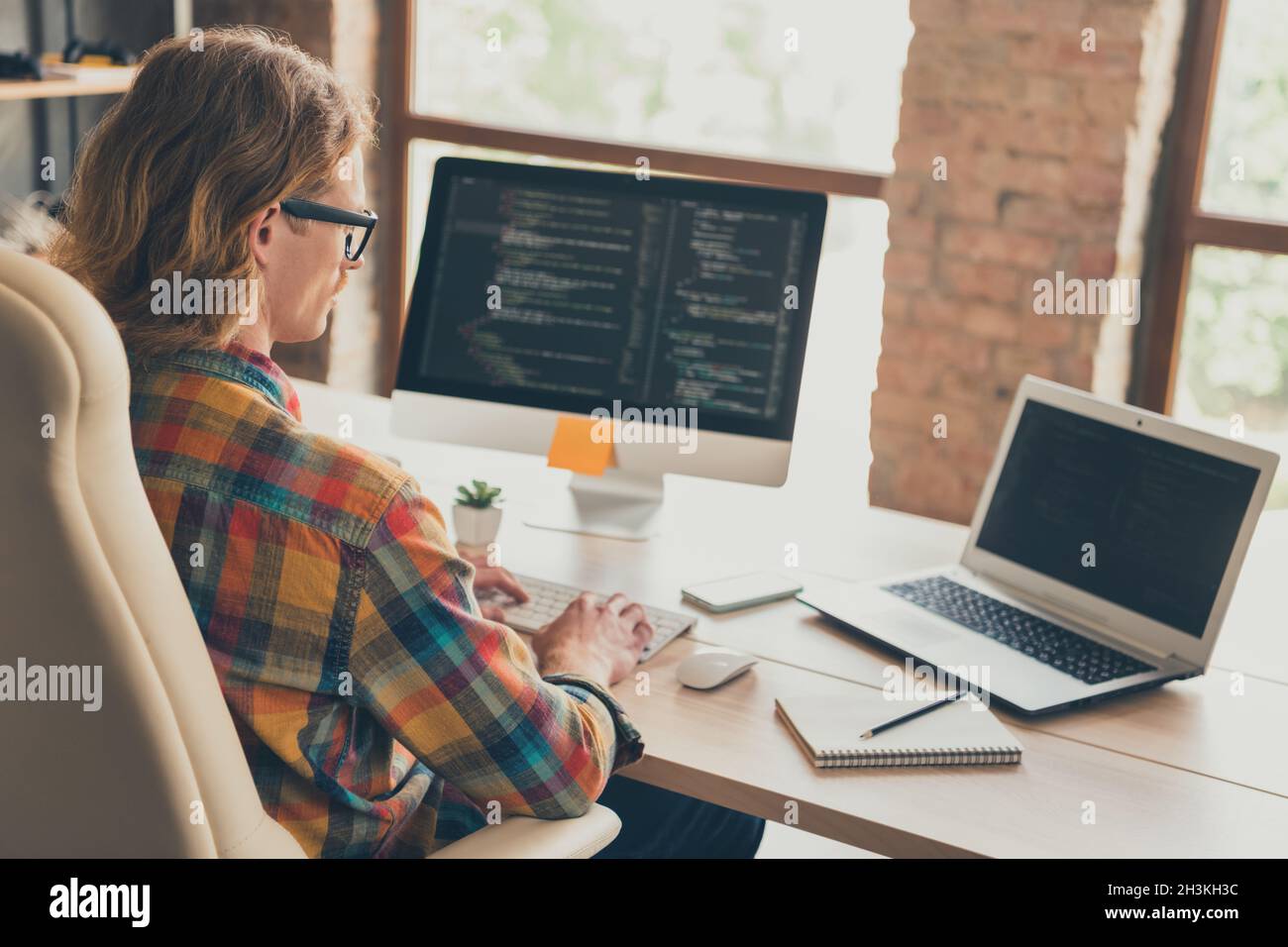 Profil Seitenfoto des jungen Mannes Arbeit online Computer Monitor IT-Spezialist Website Codierung sitzen Schreibtisch drinnen Stockfoto