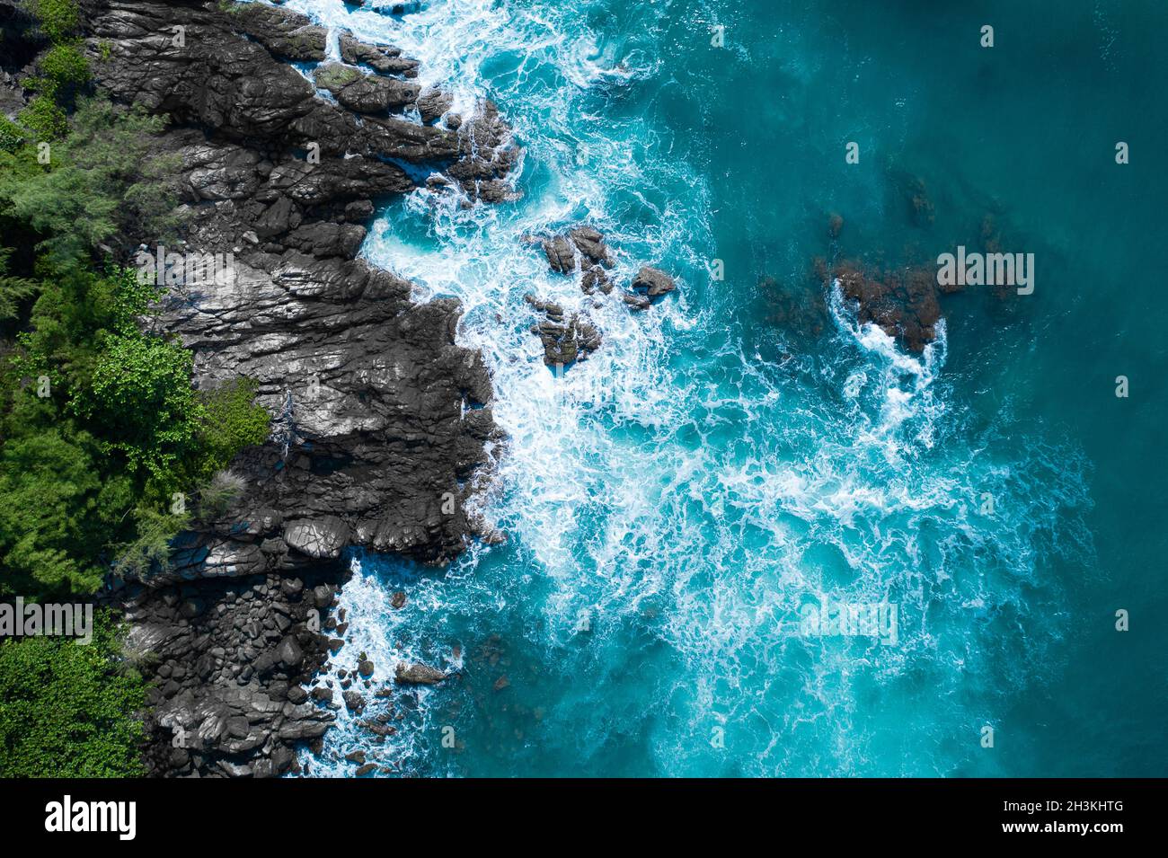 Luftaufnahme der wunderschönen Wellen des Ozeans, die an der felsigen Inselküste krachen Stockfoto
