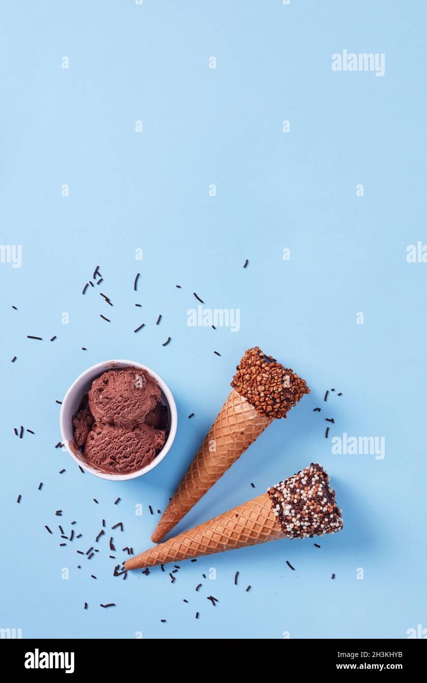 Eiszapfen und Schokoladenbecher auf blauem Hintergrund Stockfoto