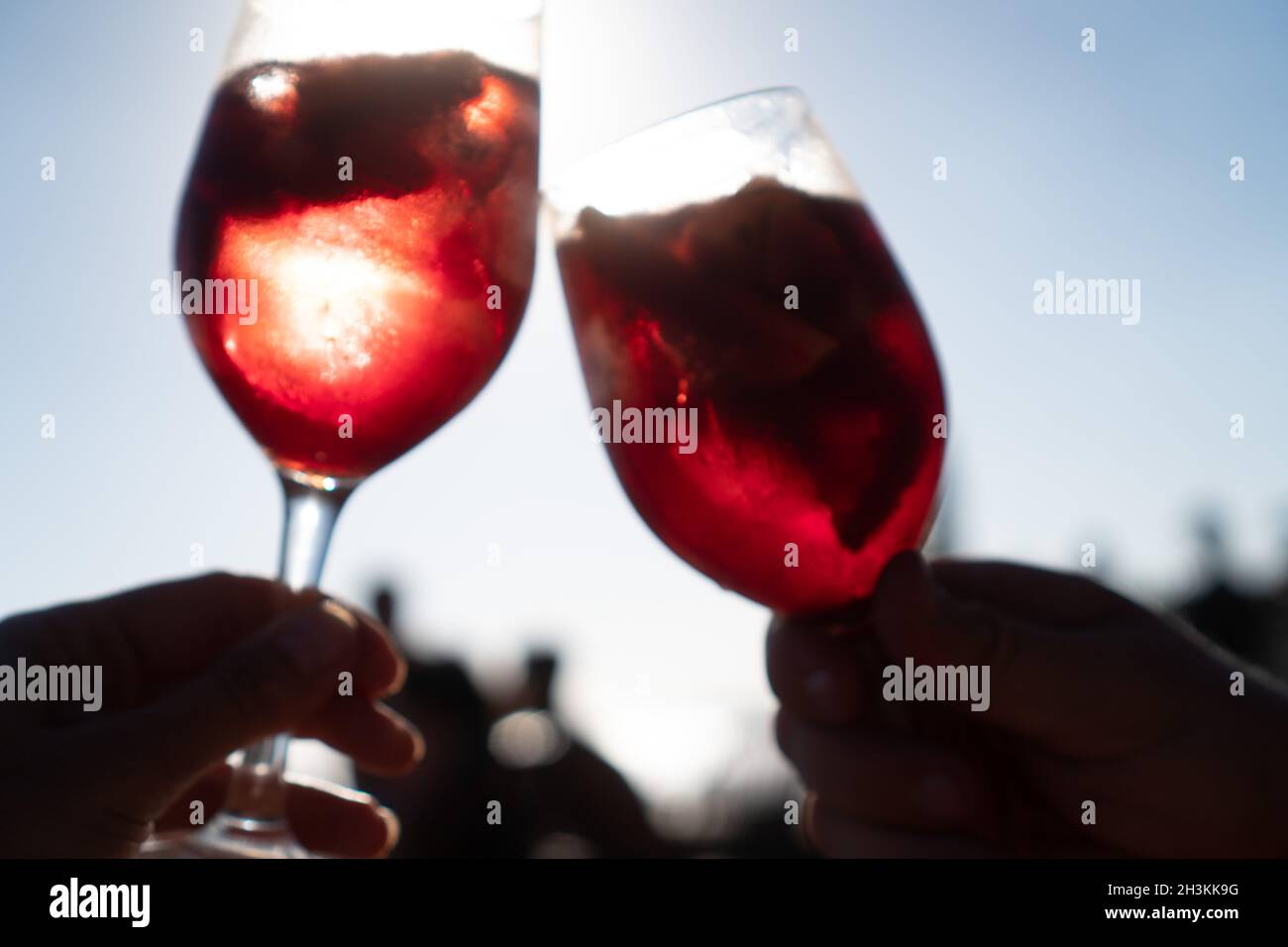 Nahaufnahme der Hände Toasten mit Gläsern Sangria mit Rotwein Stockfoto