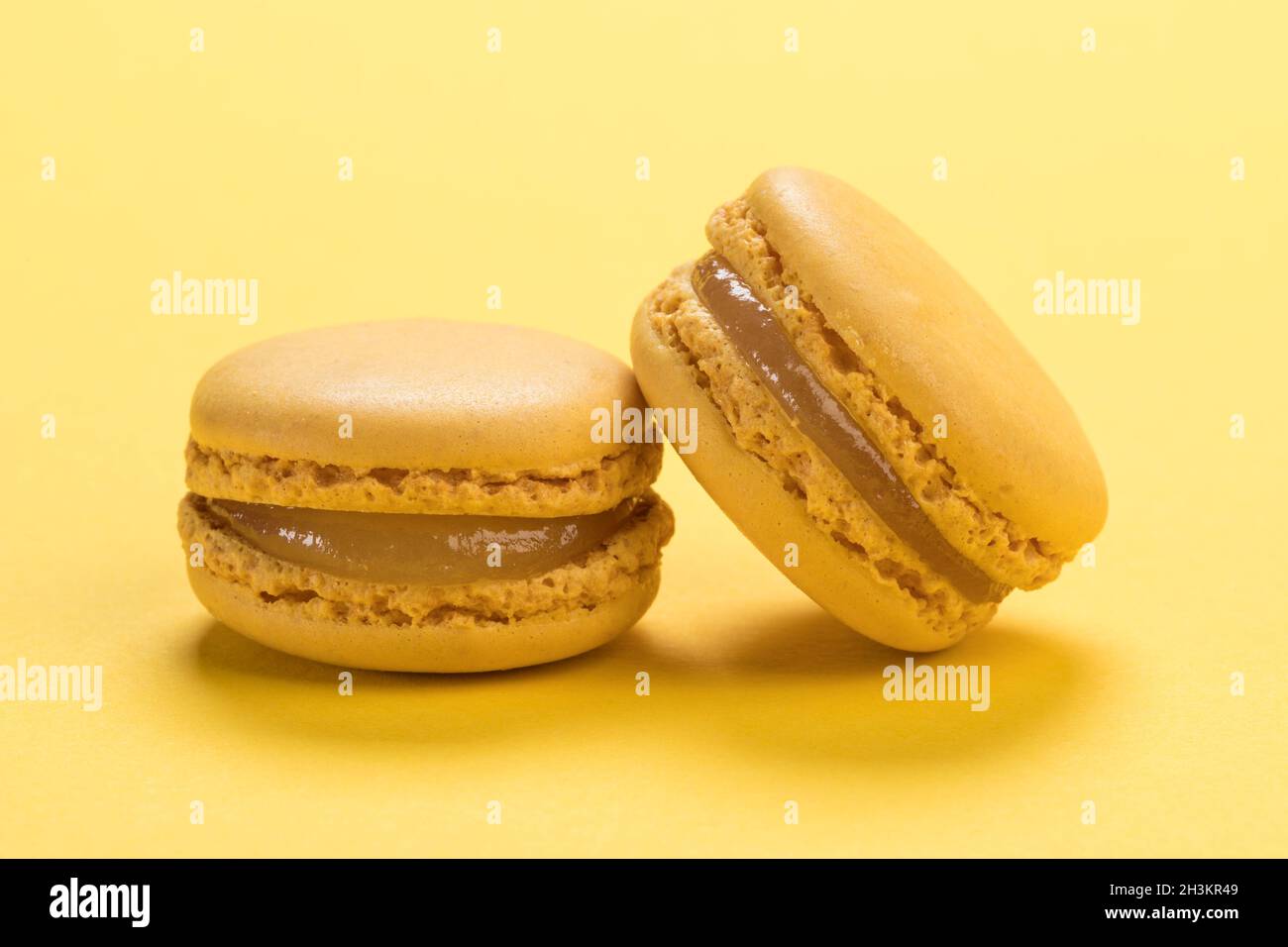 Zitronengeschmack Französische Macaronkekse Nahaufnahme auf dem Hintergrund der gleichen pastellgelben Farbe Stockfoto