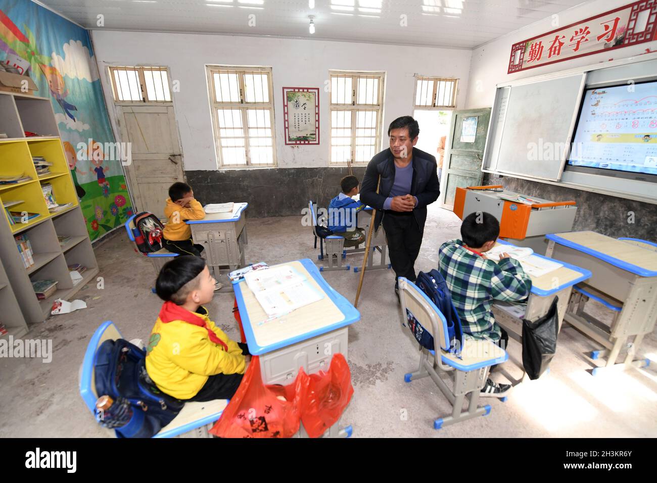 (211029) -- LINGCHUAN, 29. Oktober 2021 (Xinhua) -- die Lehrerin für ländliche Entwicklung, Qin Xingguo, unterrichtet an einer Schule in der Gemeinde Haiyang, Bezirk Lingchuan, südchinesische Autonome Region Guangxi Zhuang, 28. Oktober 2021. Die ländliche Lehrerin Qin Xingguo arbeitet im Antai-Lehrzentrum in der Gemeinde Haiyang. In den letzten 27 Jahren hat sich Qin der Aufgabe verschrieben, den Kindern hier durch Bildung bei der Verwirklichung ihrer Träume zu helfen. Als Kleinkind war Qin Xingguos rechter Fuß aufgrund von Polio gelähmt. Seit 1994 unterrichtet er an drei verschiedenen Orten, bis zu 15 Kilometer von zu Hause entfernt. „aufgrund meiner Beinbehinderung ist es das Stockfoto